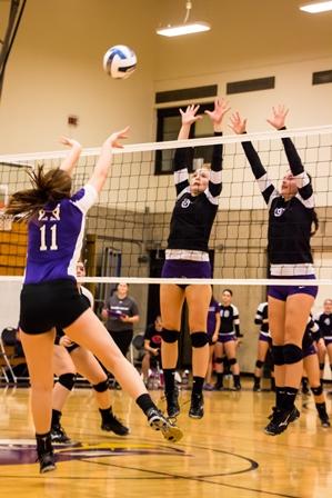 Freshmen Lindsay Gerding  (from left) and Syd Walker go for a block against Lincoln in the Eagles first home game. 