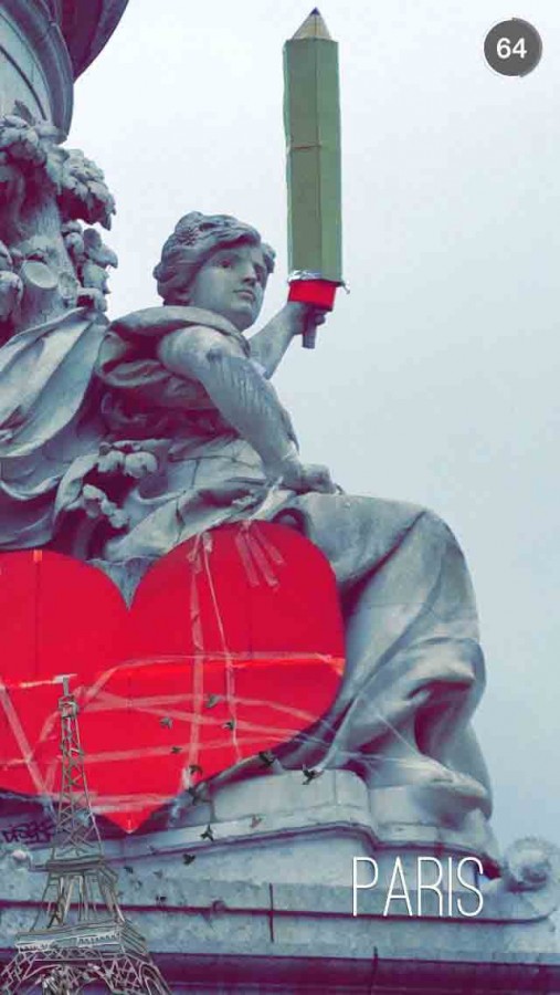 A Snapchat image, one of many circulating on social media, depicts a “Liberty” statue in the Place de la Republique in Paris bearing a pencil to honor the fallen journalists. Several protests directed at the attack used this plaza as a focal point.
