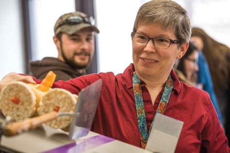 Cynthia Shultz, IVCC mathematics instructor, adjusts her car which received third place for creativity, preparing it for its descent down the ramp for competition at the Edible Car Competition in celebration of National Engineers Week. 