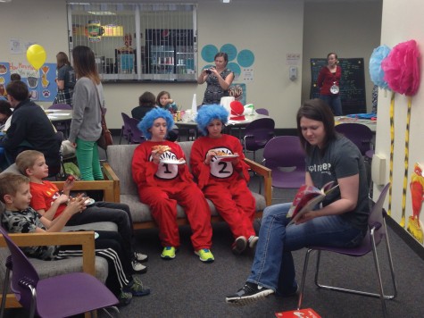 Chelsea Berg (right) reads a story as part of the games and activities for Dr. Seuss’ birthday event March 3 in the cafeteria as Thing 1 & 2 (Aubrey Molln and Mack Borio) look on.