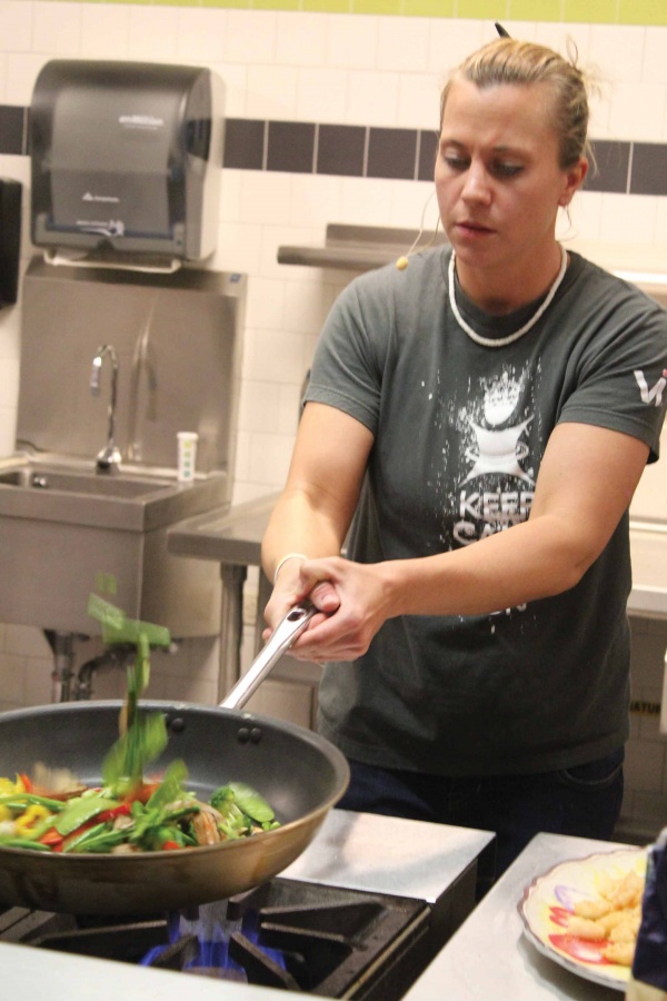 Former IVCC student Sara Fitzpatrick flips vegetables to be used in her sweet red chili shrimp stir fry during her Five Ingredients or Less class, offered as part of the Continuing Education program at IVCC.