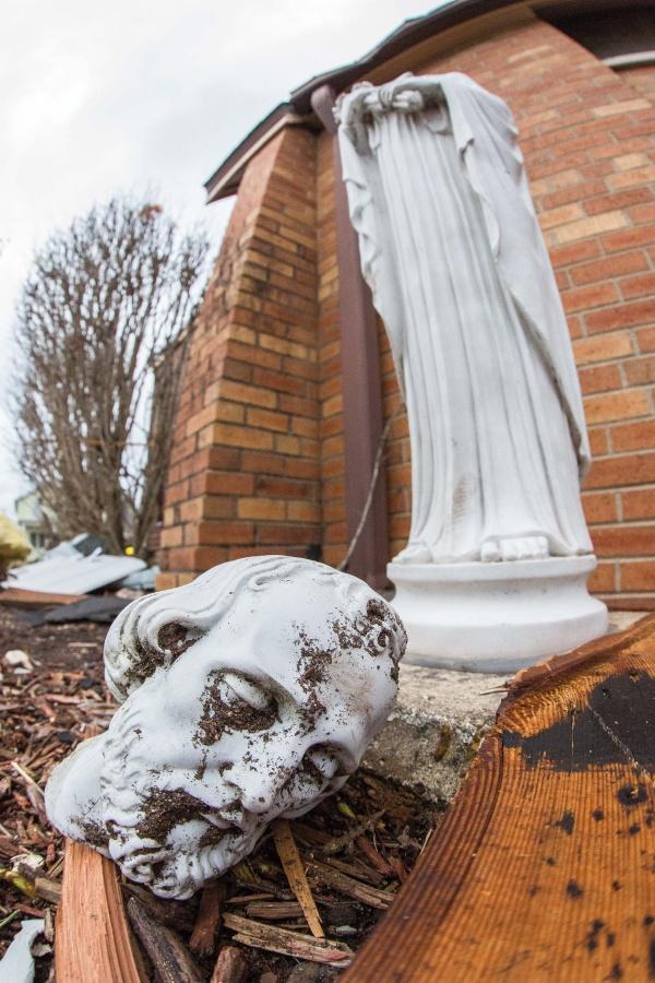 The head of a statue of Christ appears to cry thanks to a streak of dirt under his eye as a result of the storm.