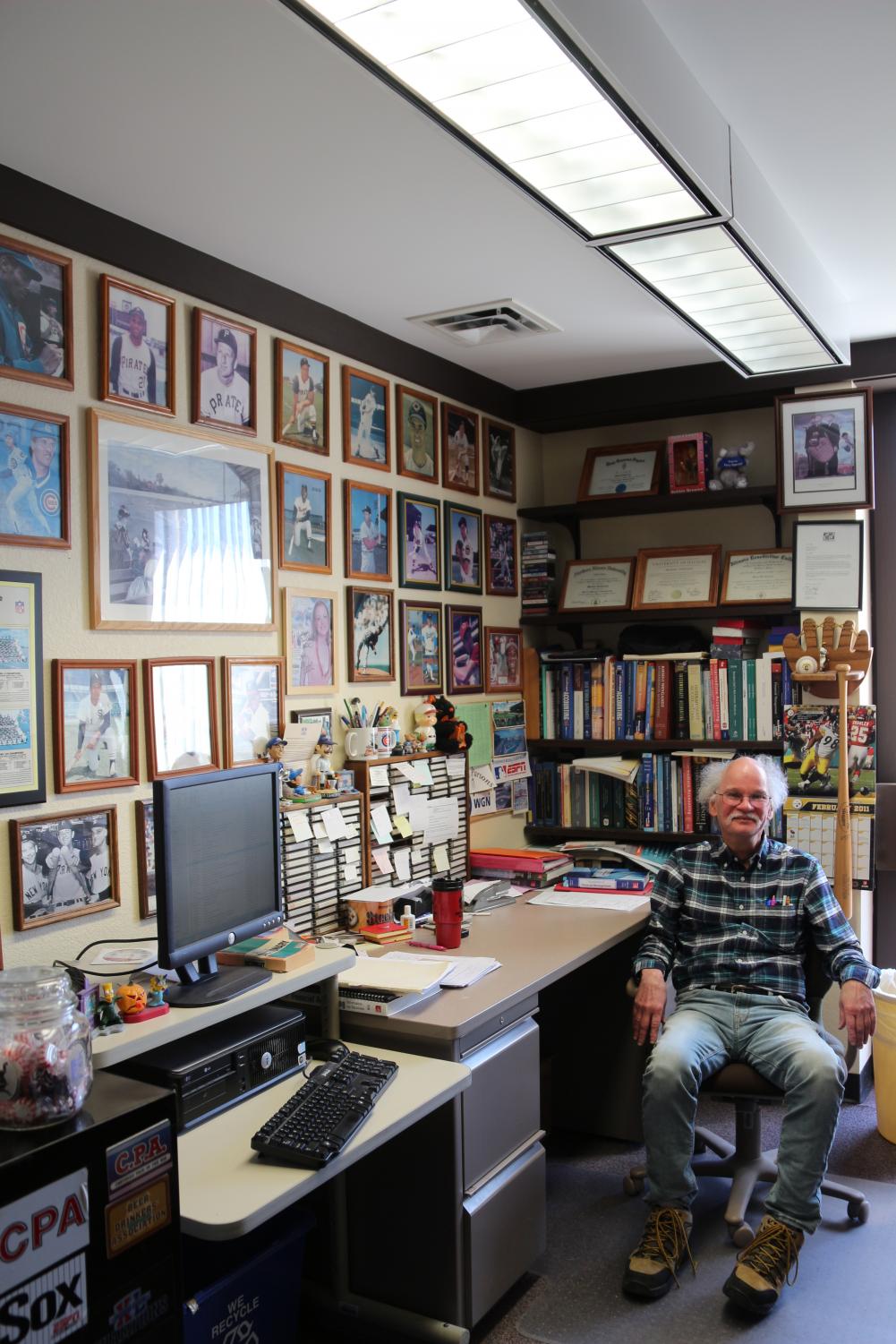Retiring accounting professor Mike Sankovich sits in his office surrounded by his other passions: movie and baseball memorabilia and music.