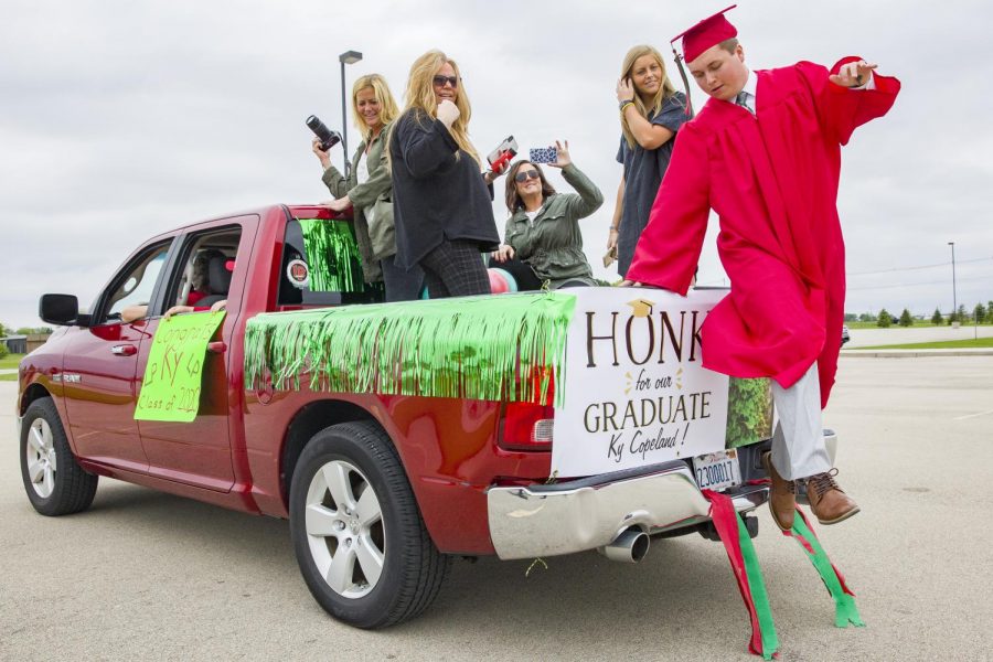 LaSalle-Peru Township High School student Ky Copeland jumps out of the bed of his familys truck to head up onto the graduation stage set up for the drive thru graduation. Two vehicles were allowed but all guests watching were required to stay  in their vehicles.