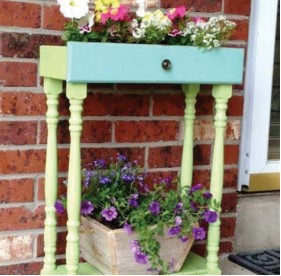 An old dresser is repurposed into a flowerbox, full of colorful flowers that have been planted in a drawer. Picture from allideen.