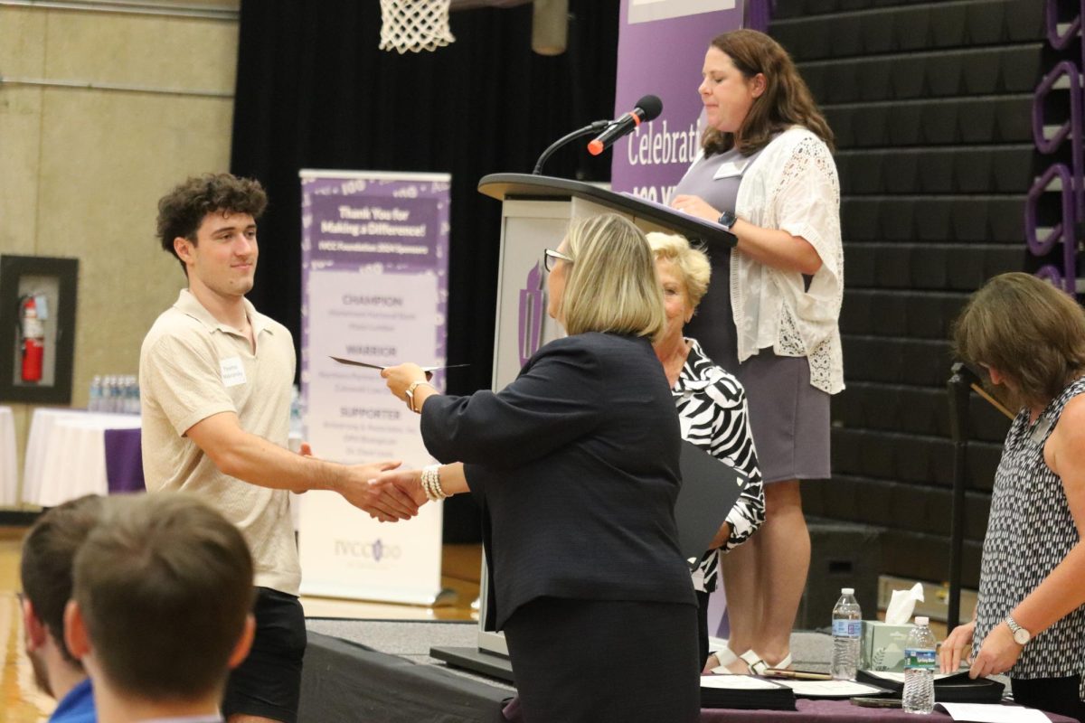 Student receives their scholarship.